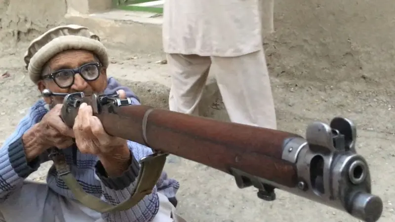 حسن گل وہ رائفل پکڑے ہوئے ہیں جو انھوں نے پنڈو کی لڑائی کے دوران استعمال کی تھی۔
